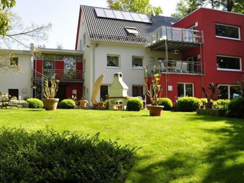 Modernisiertes Zweifamilienhaus mit rotem Anbau und großem Garten